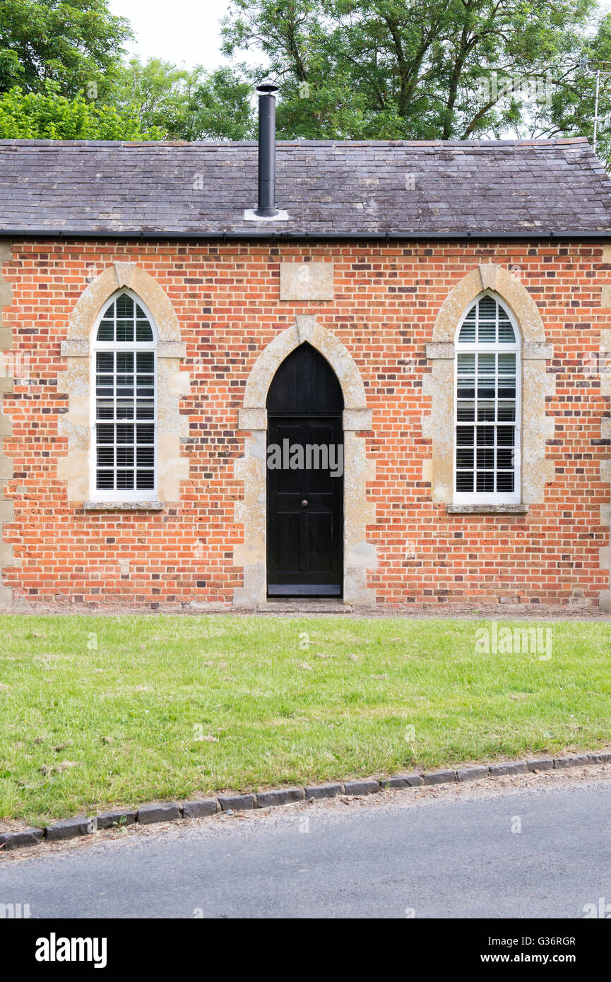 Converted chapel house with arched windows and door in Black Bourton. Oxfordshire, England Stock Photo