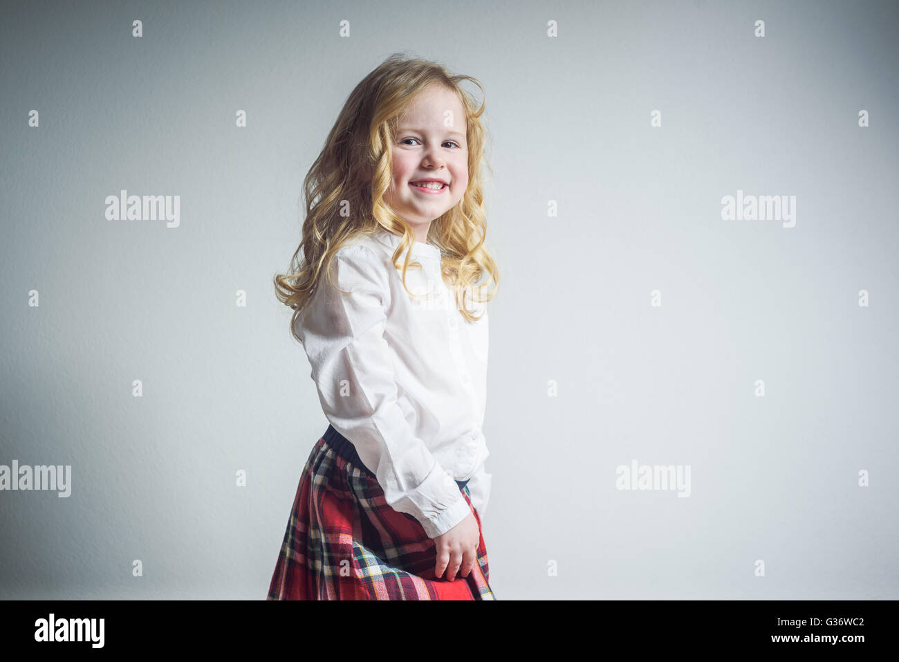 Beautiful smiling blond girl in a school uniform Stock Photo