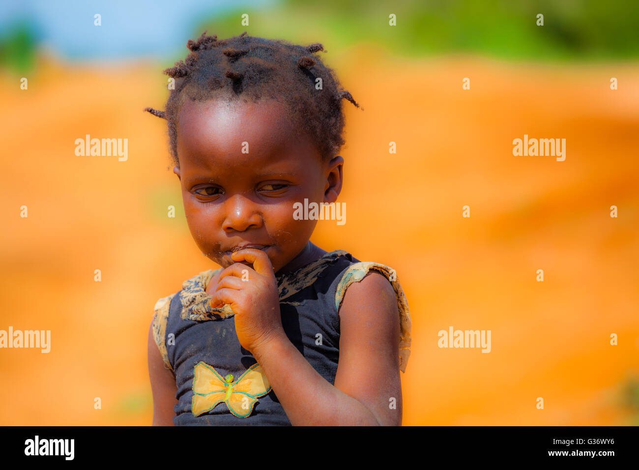 A very small young girl in the middle of african savana Stock Photo