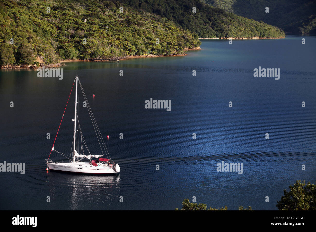A yacht reflects the wake of a longpassed water taxi at Punga Cove