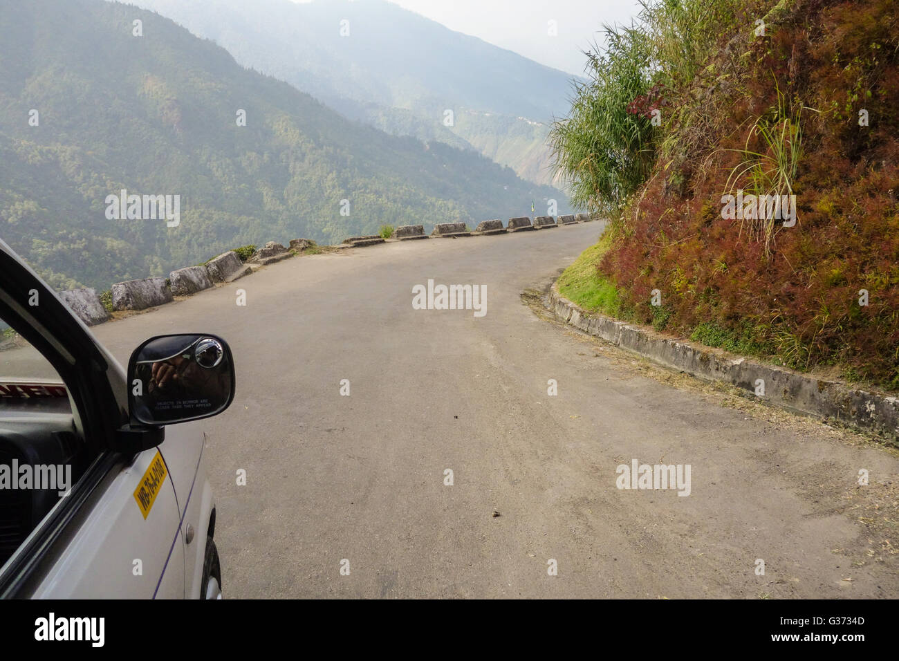 View from car passenger seat - Just another sharp right curve along the curvy Bloomfield Road leading to Rock Garden, Darjeeling Stock Photo