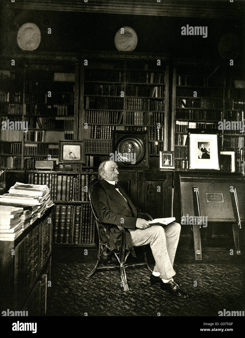 WILLIAM EWART GLADSTONE in his library : he was a  classical scholar of  considerable ability.       Date: 1809 - 1898 Stock Photo