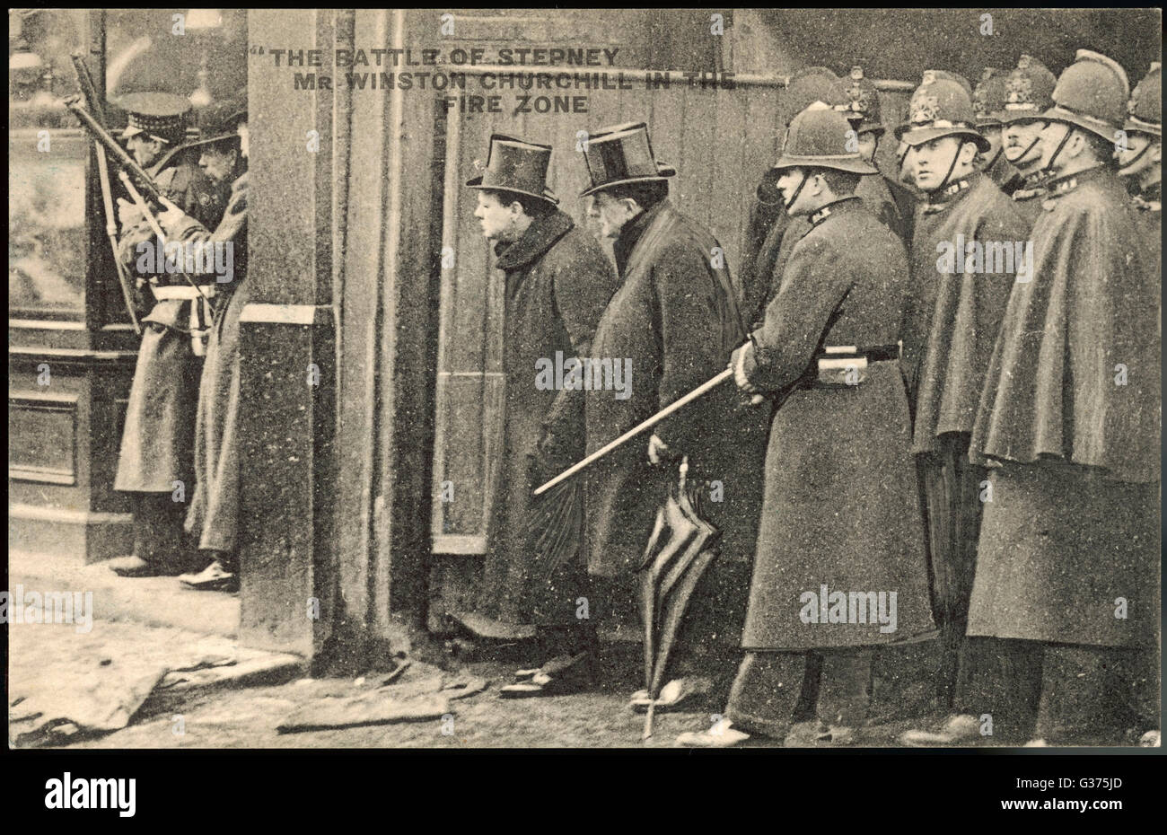 WINSTON CHURCHILL, then Home Secretary,  is seen with a with a posse of policemen during the Siege of Sidney Street  in Stepney, London.     Date: 3 January 1911 Stock Photo