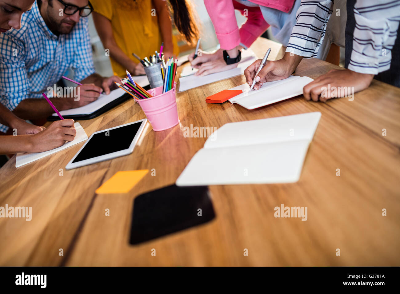 Casual business team writing in notebooks Stock Photo