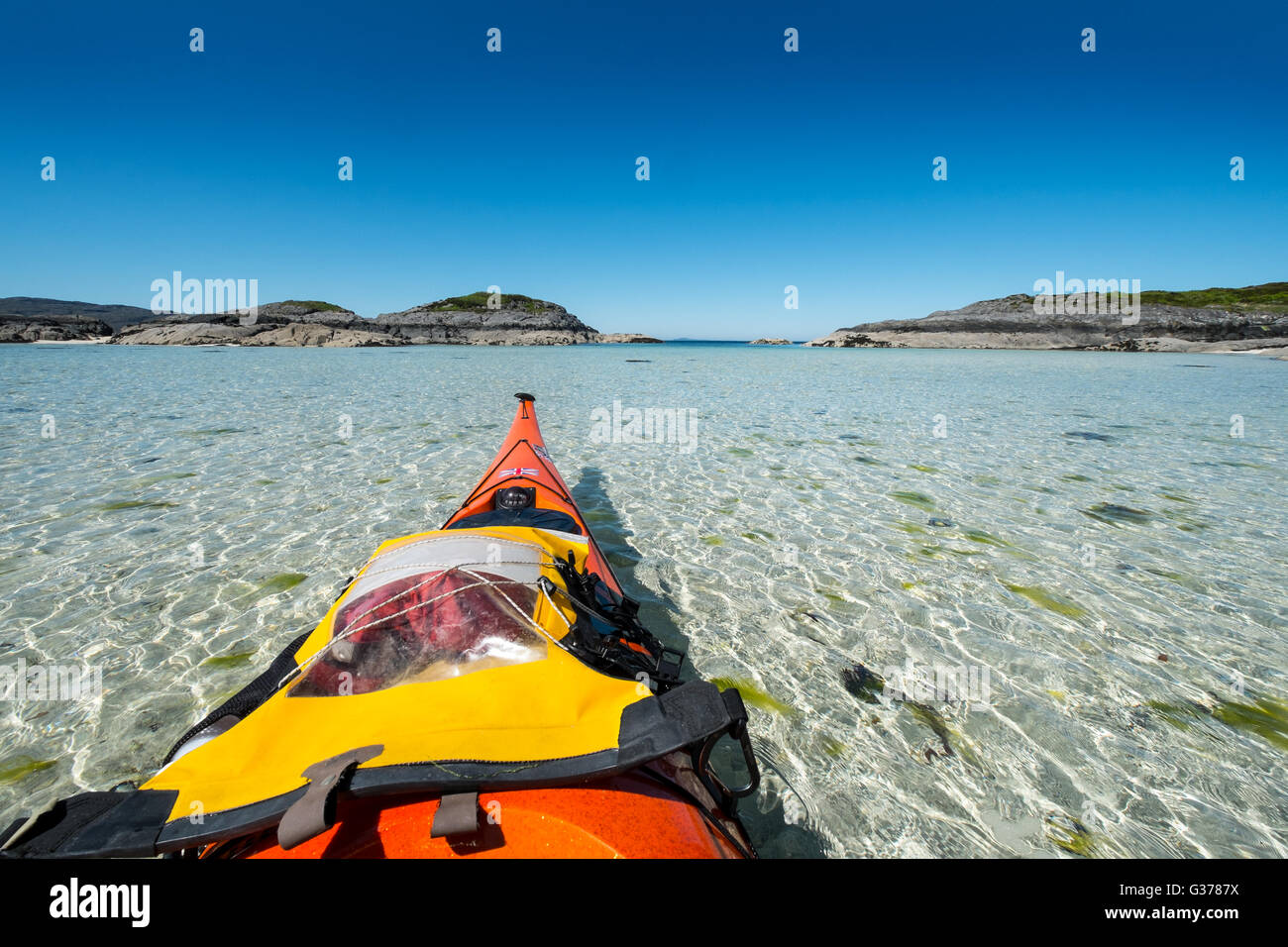 Sea kayaking in the crystal clear waters off the west coast of  Scotland, in the Arisaig to Moidart area Stock Photo