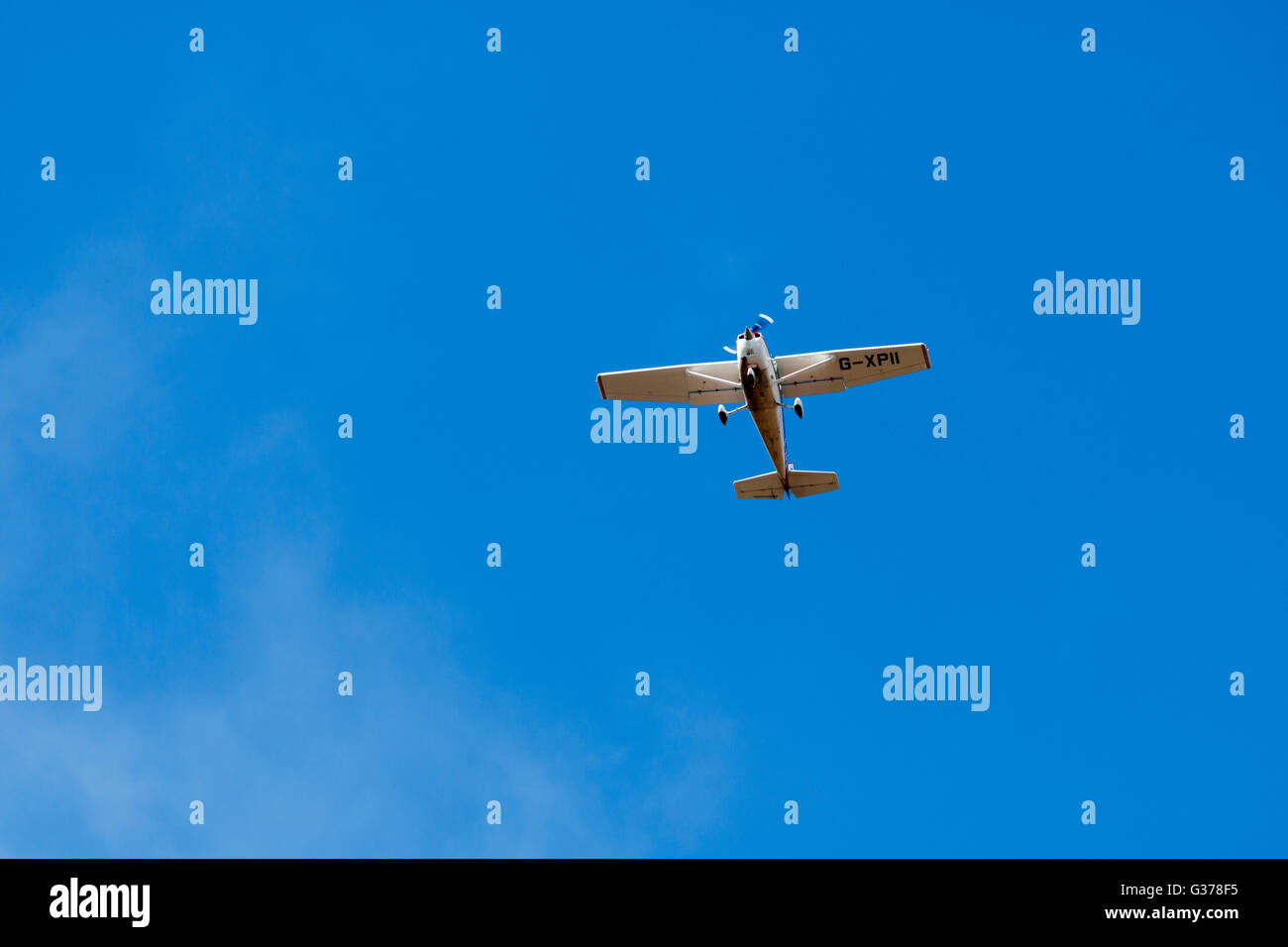 Single prop plane flying in blue skies England Stock Photo