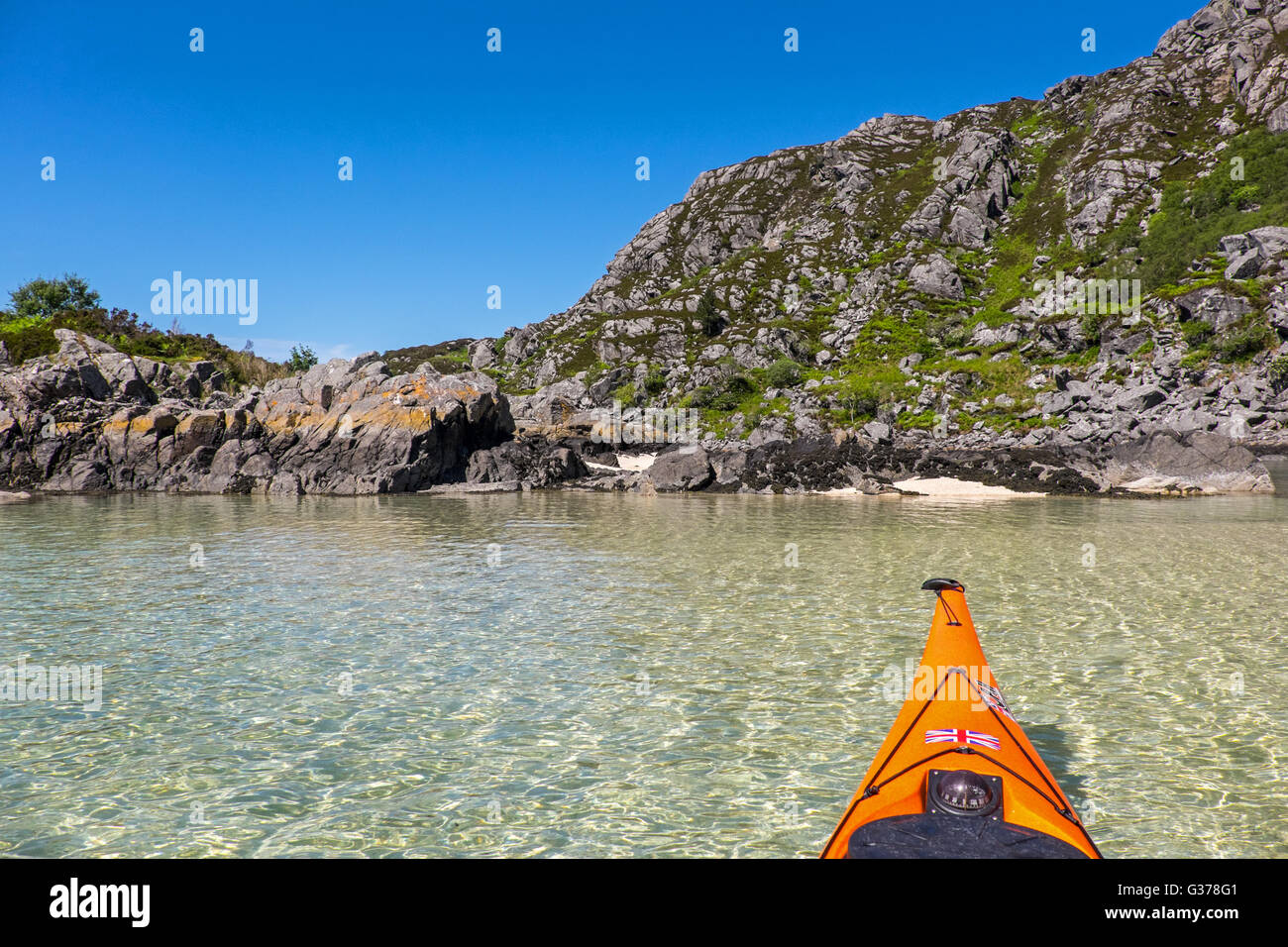 Sea kayaking in the crystal clear waters off the west coast of  Scotland, in the Arisaig to Moidart area Stock Photo