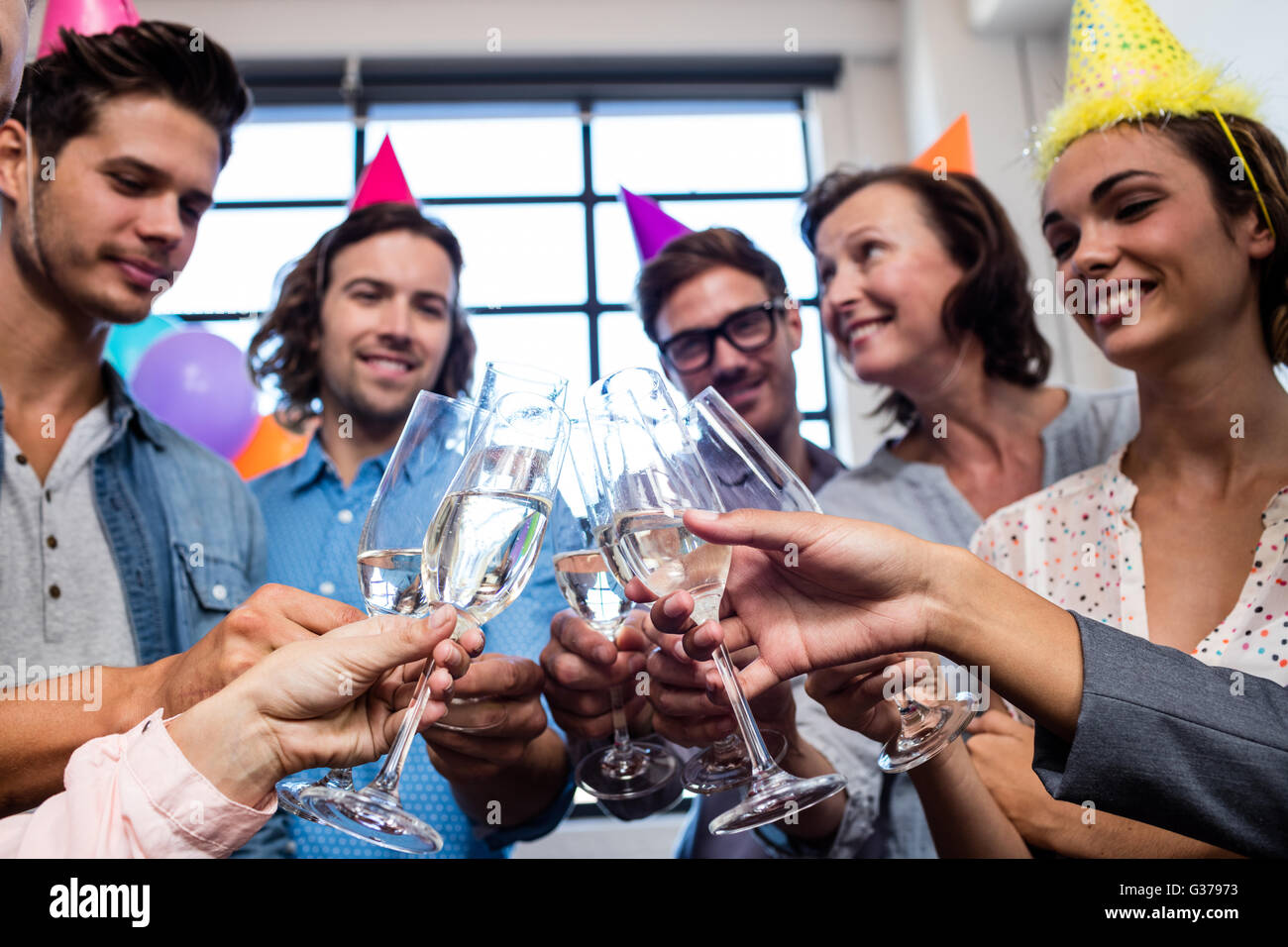 Happy coworker drinking champagne to celebrate a birthday Stock Photo