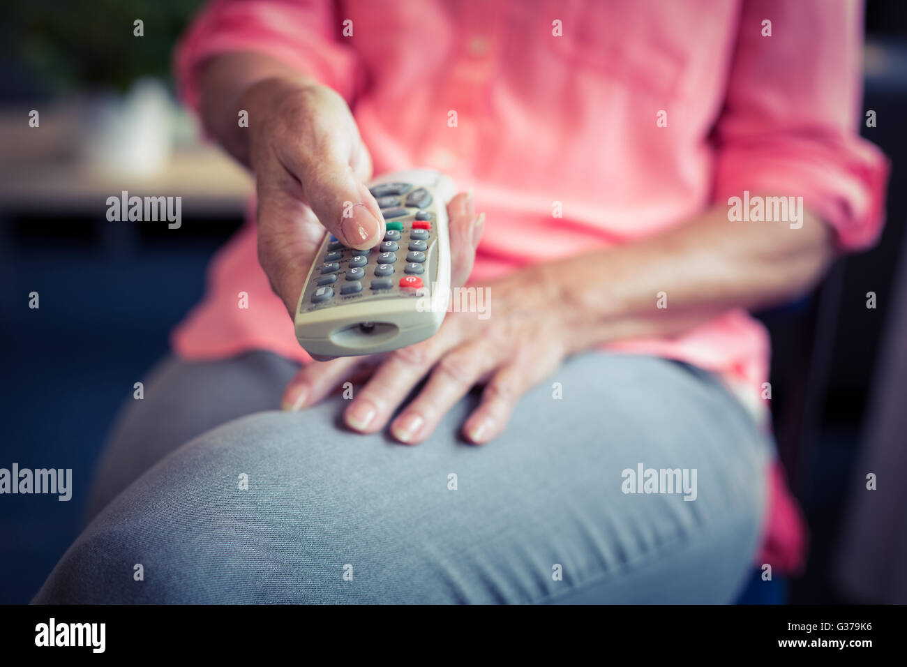 Senior woman changing tv channel Stock Photo