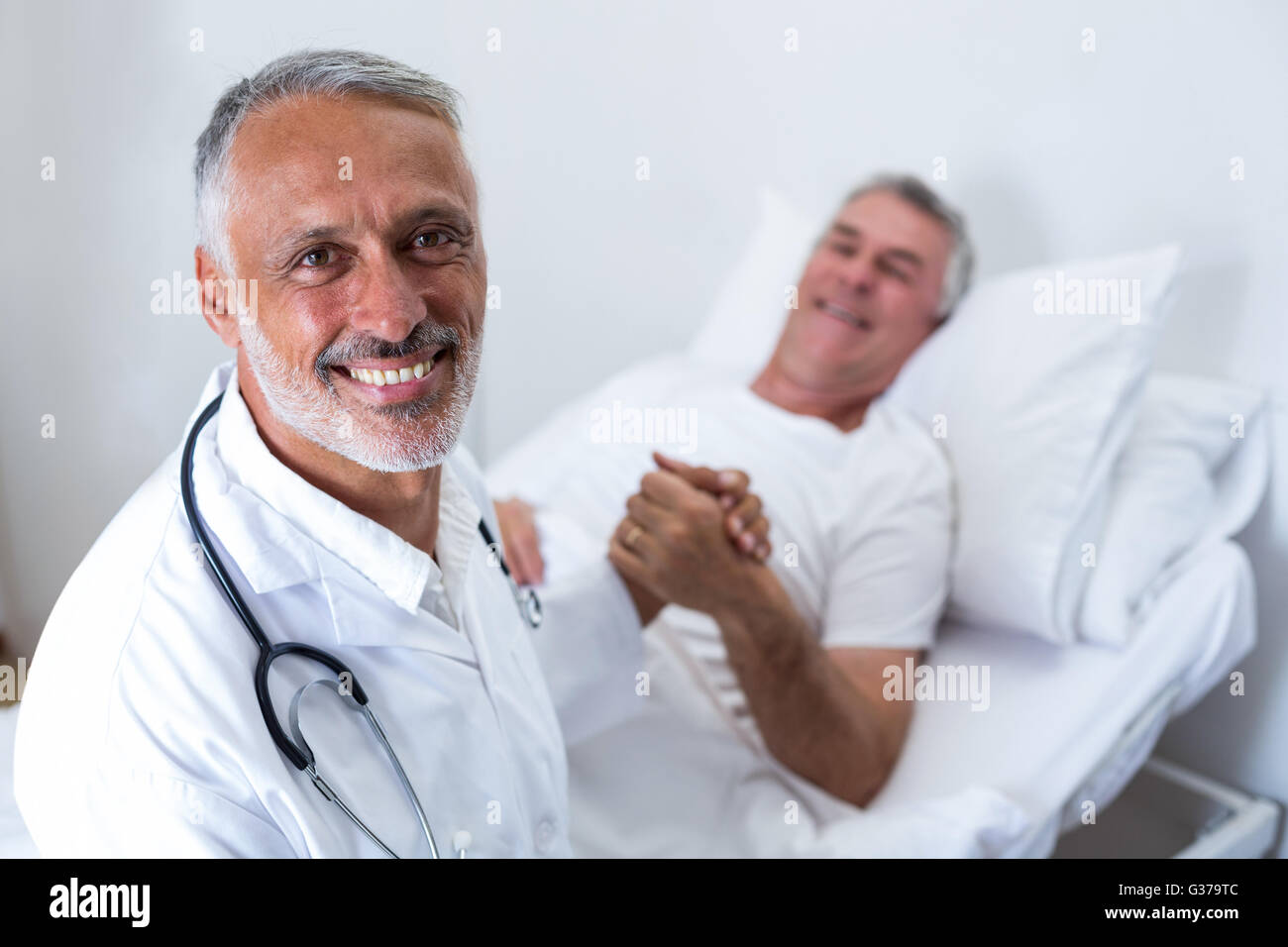 Male doctor consoling senior man Stock Photo