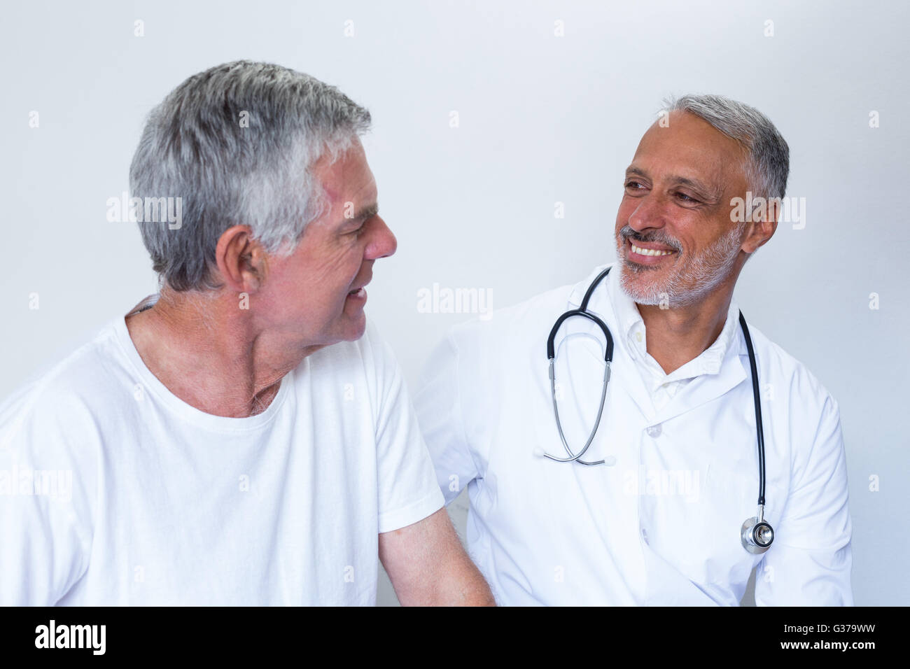 Male doctor and senior man interacting with each other Stock Photo