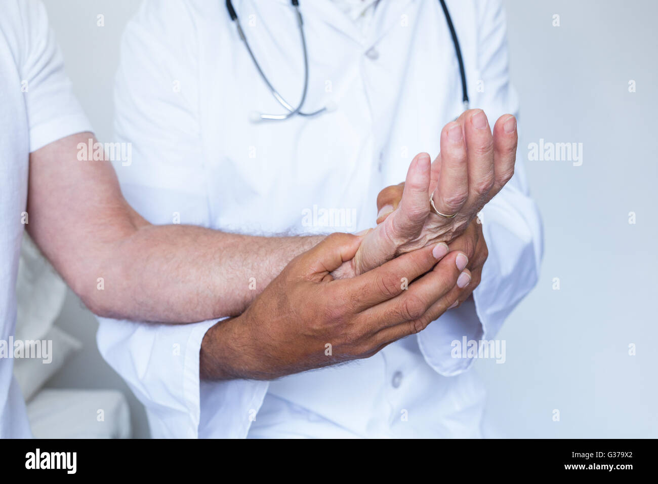 Male doctor giving palm acupressure treatment to the patient Stock