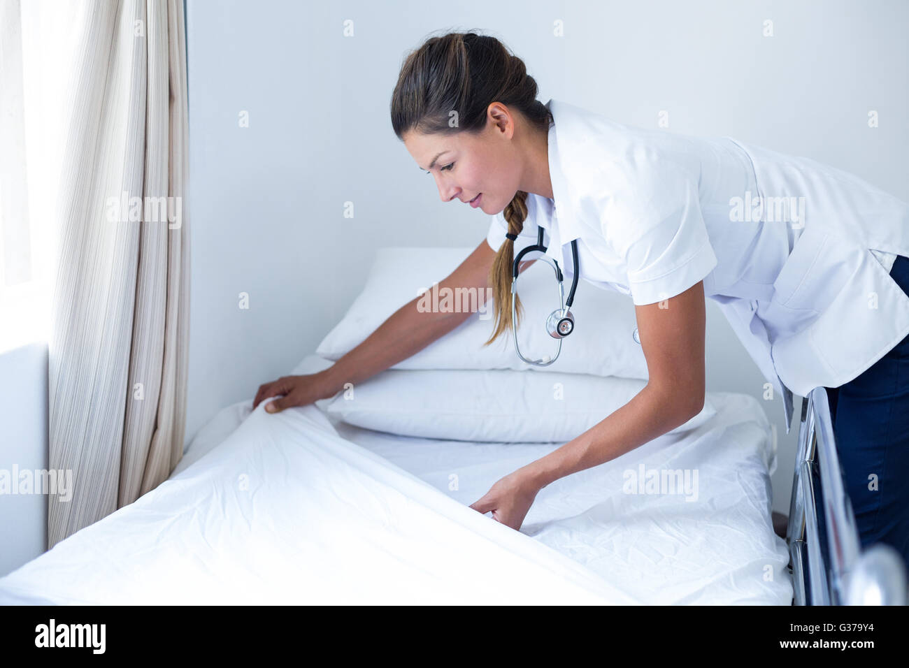 Подготовка постели. Заправленная кровать в больнице. Медсестра меняет постельное белье. Подготовка постели пациенту.