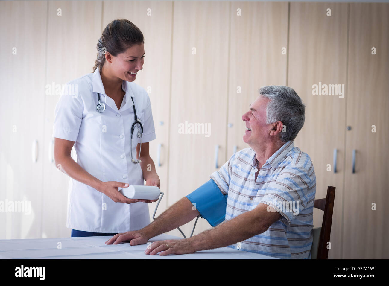 Doctor checking blood pressure hi-res stock photography and images - Alamy