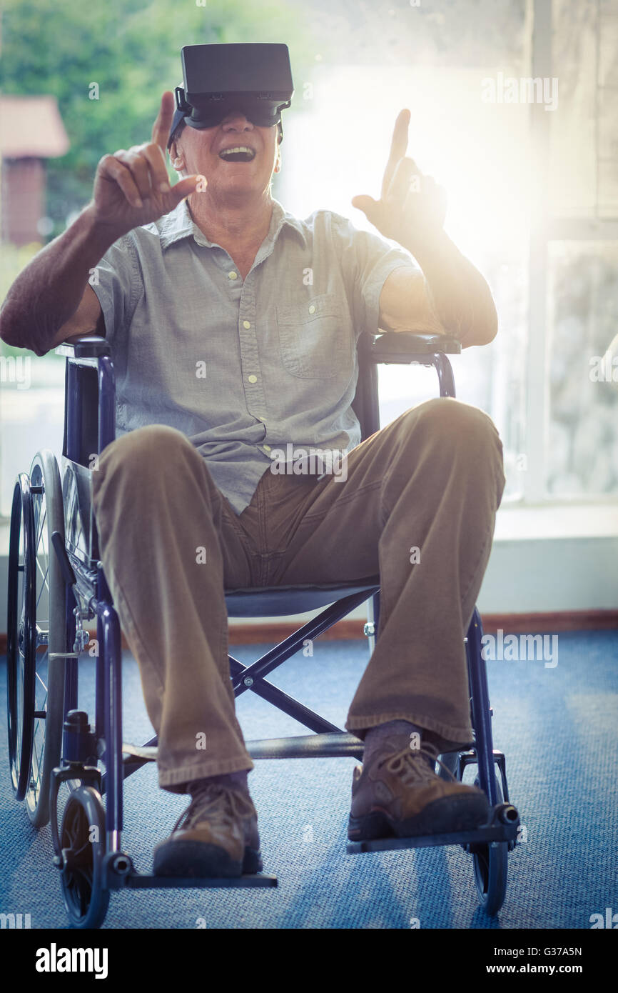 Happy senior man on wheelchair using VR headset Stock Photo