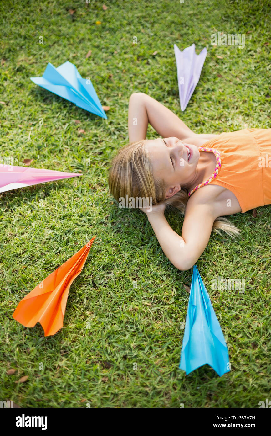 Young girl lying on grass around paper planes Stock Photo - Alamy