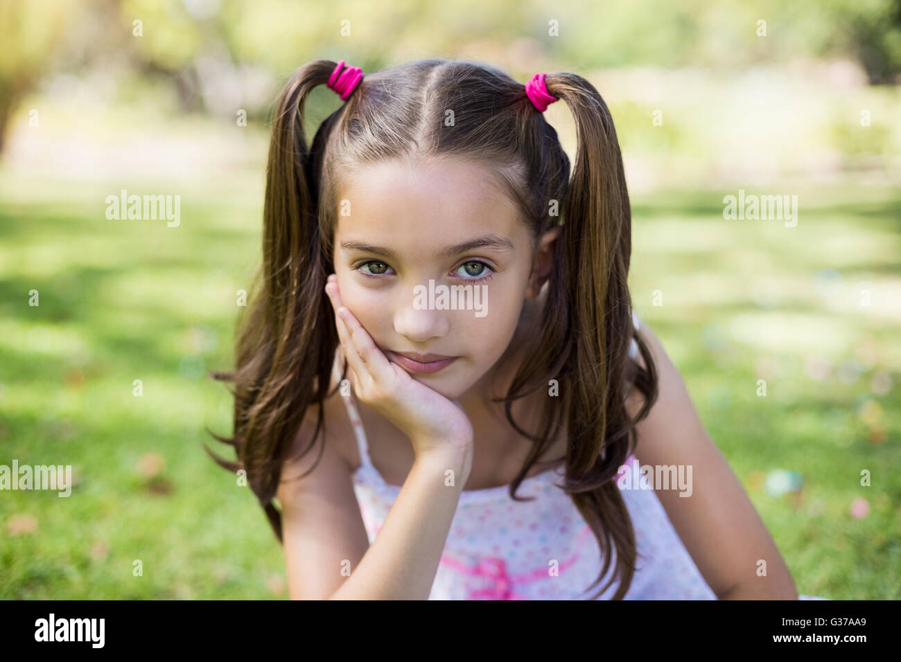 Upset girl sitting with hand on chin Stock Photo - Alamy