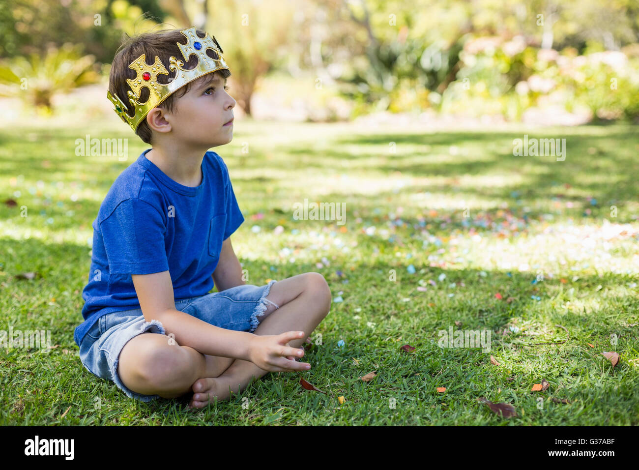 Young boy sitting in park Stock Photo