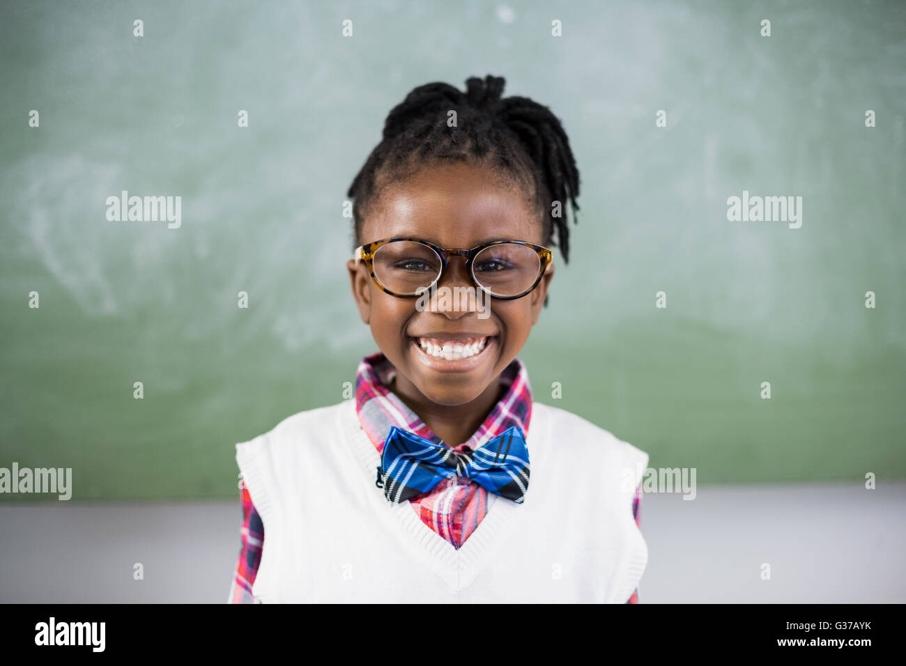 Portrait of schoolgirl smiling in classroom Stock Photo - Alamy