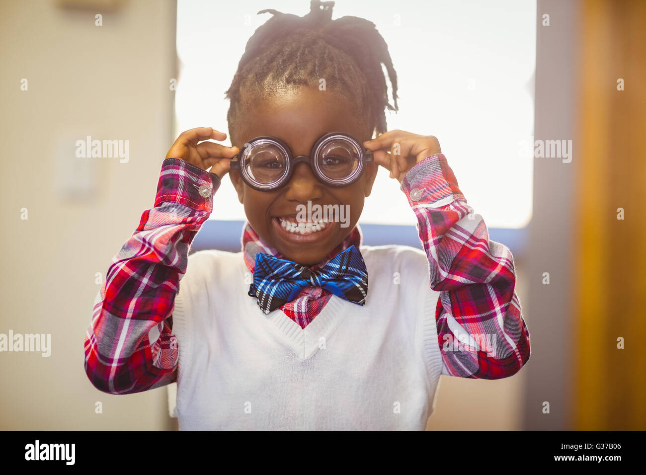 Portrait of happy schoolgirl in spectacle smiling in classroom Stock ...