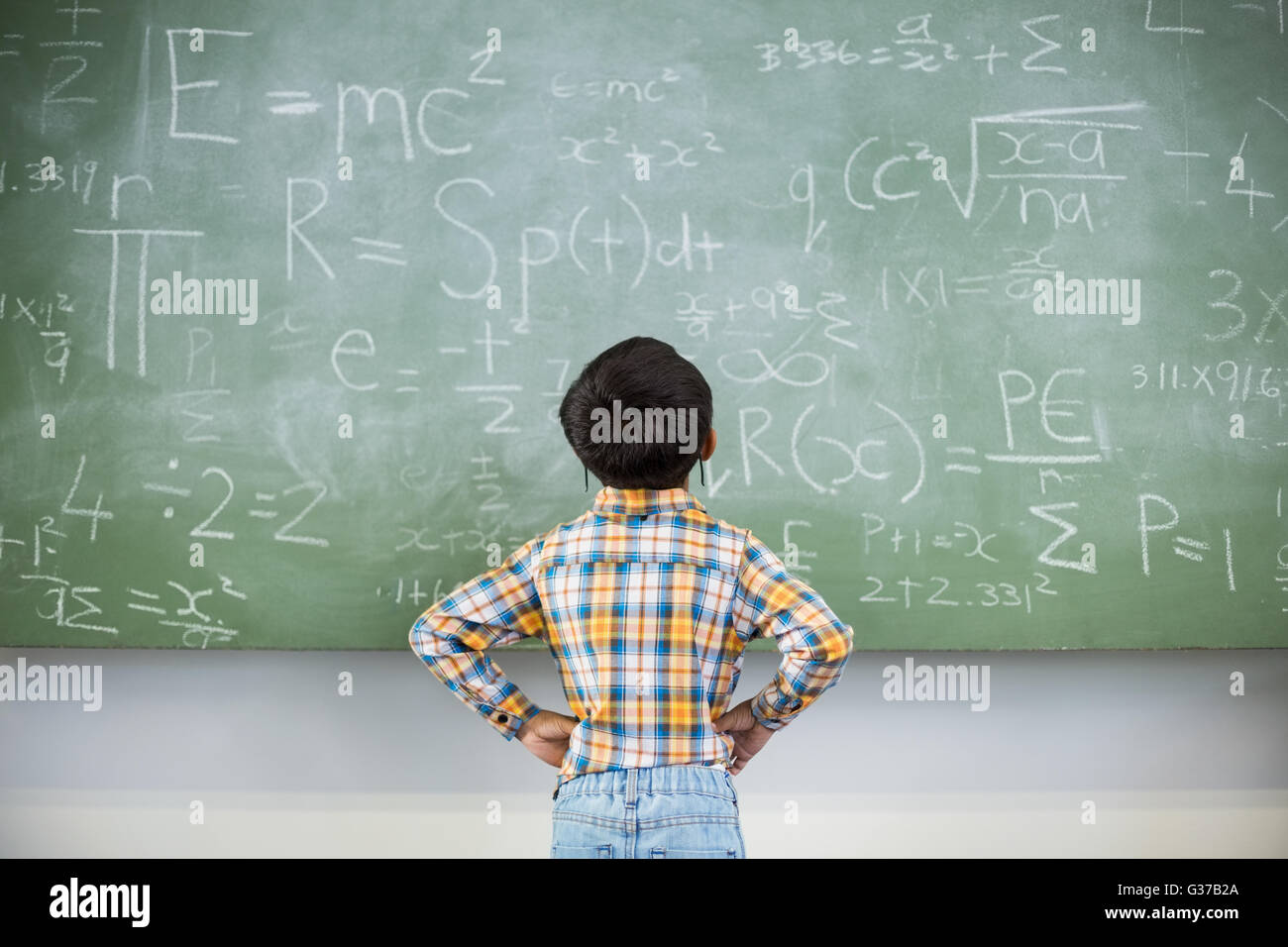Student Looking At Math Schoolboy looking mathematics on chalkboard in classroom Stock Photo ...