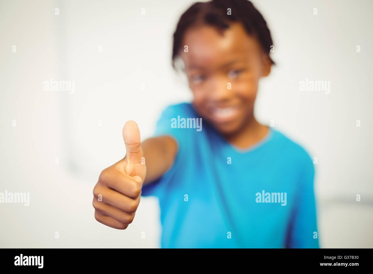 Portrait of smiling schoolboy showing thumbs Stock Photo - Alamy