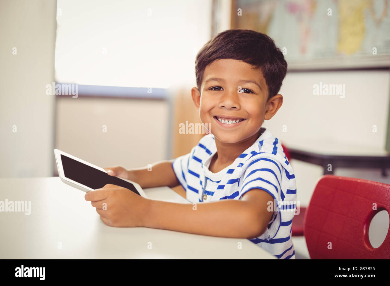 Portrait of schoolboy using digital tablet in classroom Stock Photo - Alamy