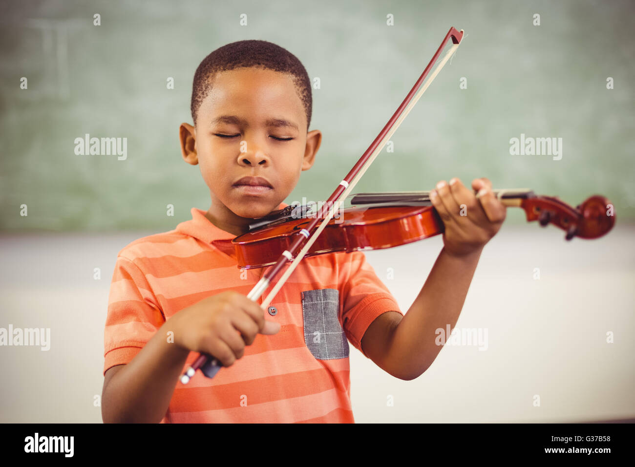 Schoolboy playing violin in classroom Stock Photo - Alamy