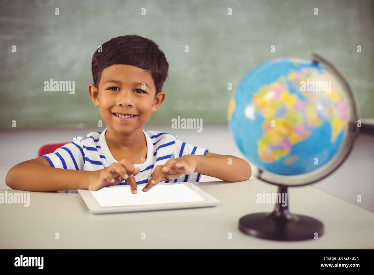 Portrait of schoolboy using digital tablet in classroom Stock Photo - Alamy