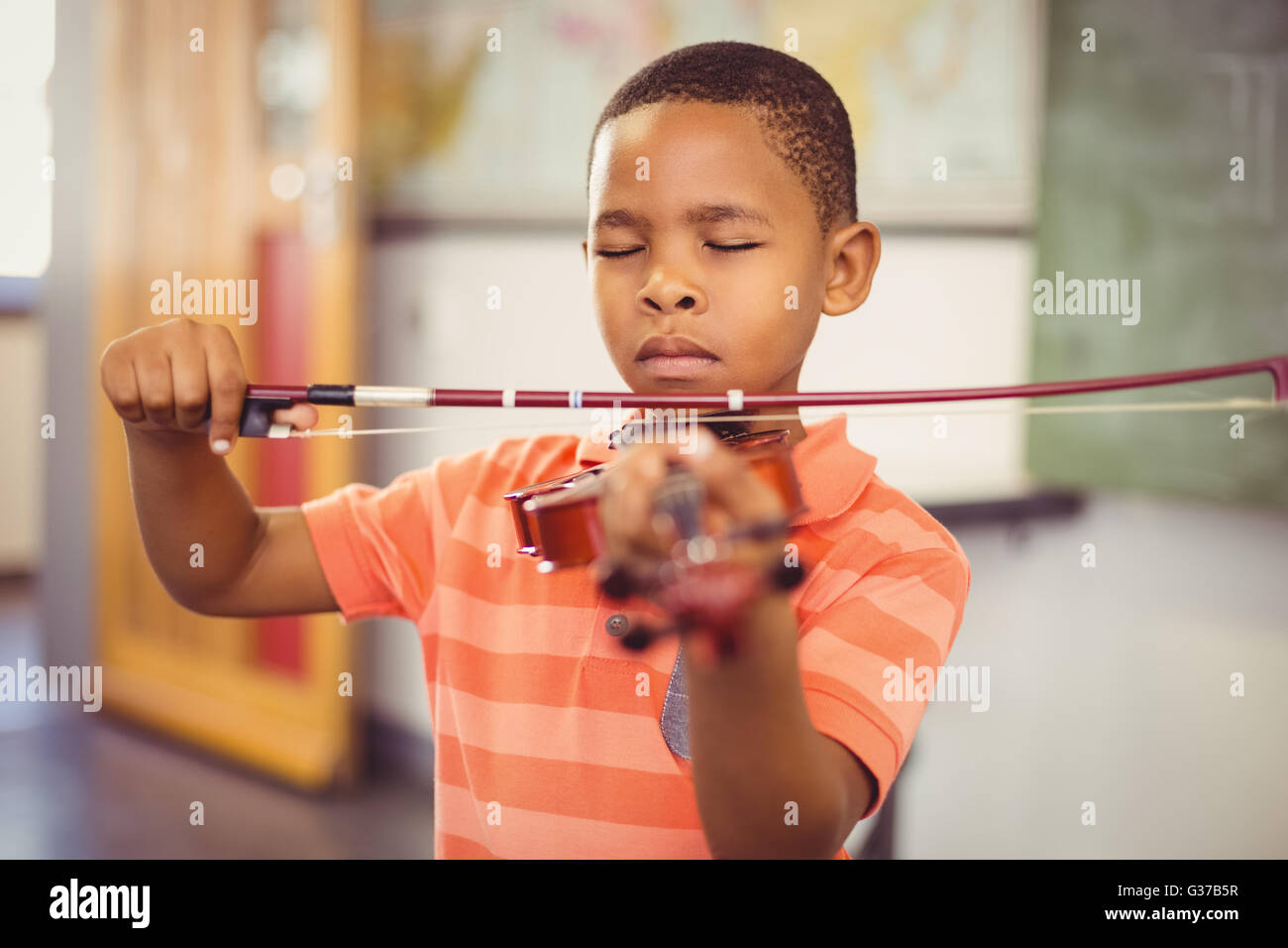 Schoolboy playing violin in classroom Stock Photo - Alamy