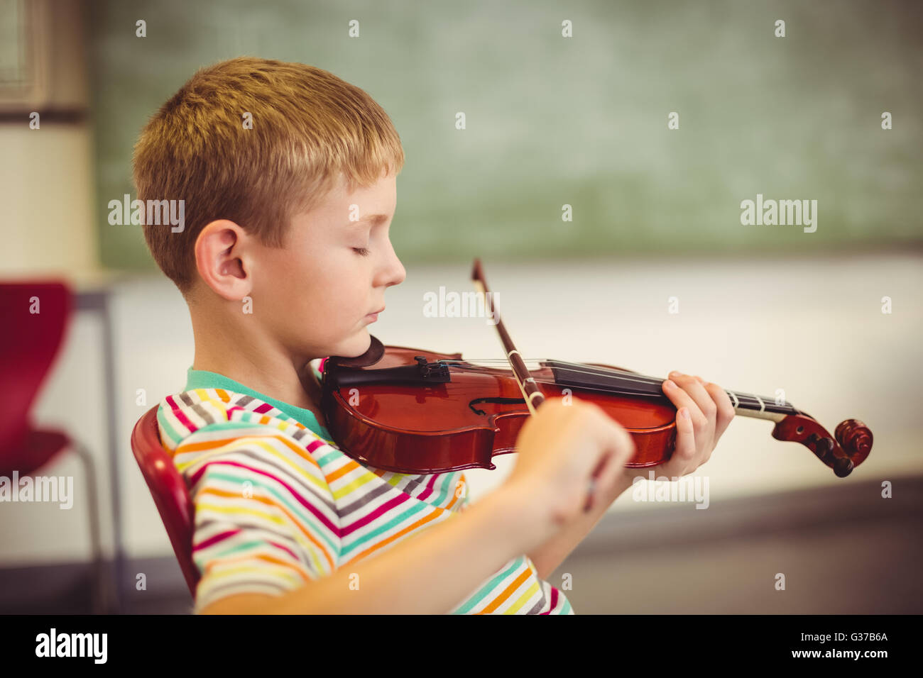 Schoolboy playing violin in classroom Stock Photo - Alamy