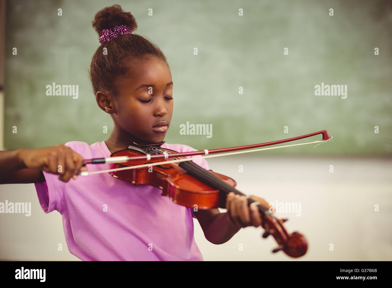 Schoolgirl playing violin in classroom Stock Photo - Alamy