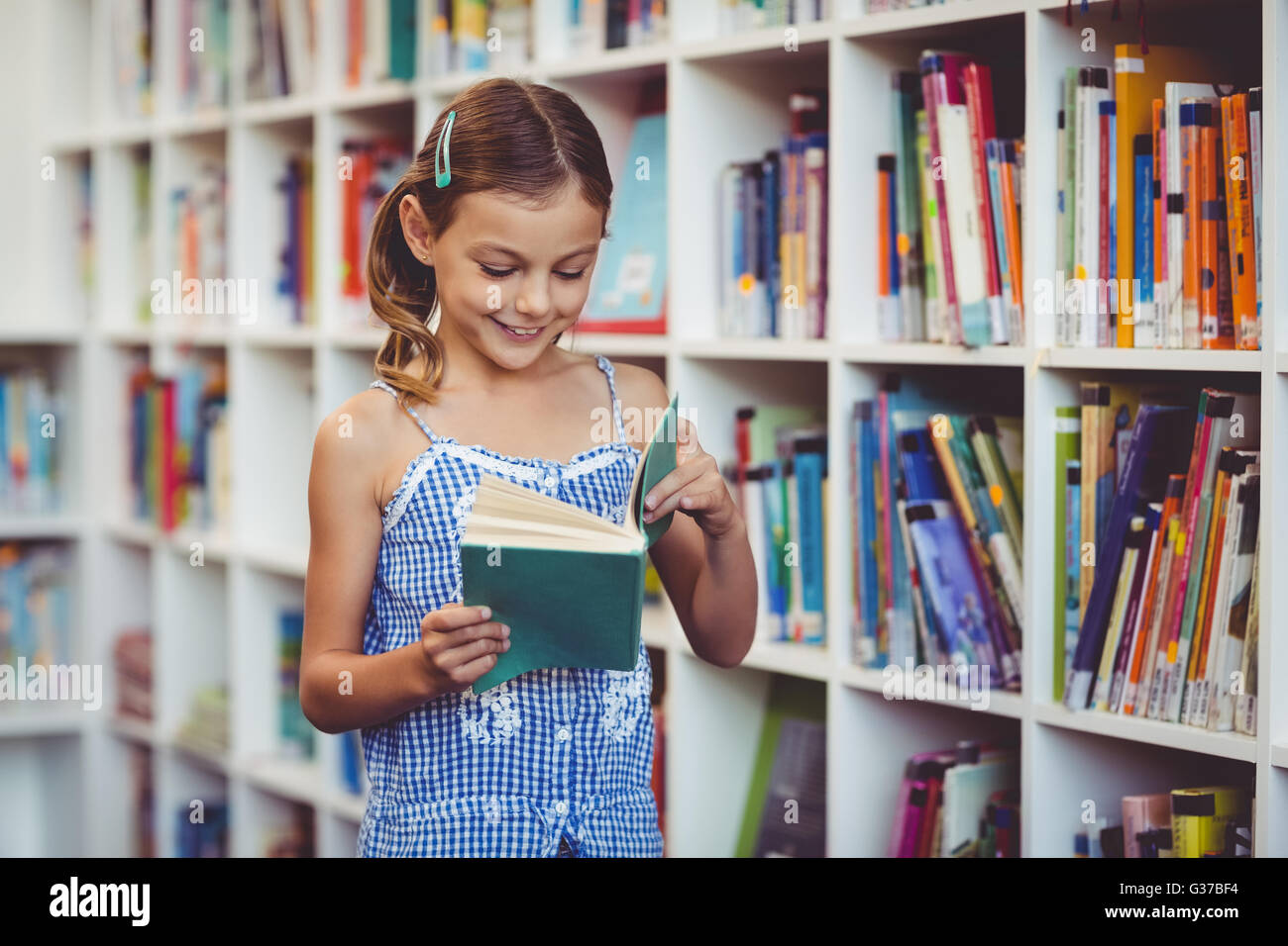 School girl reading a book in library Stock Photo - Alamy