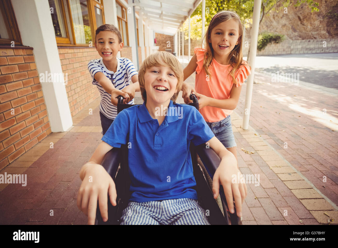 School kids pushing a boy on wheelchair Stock Photo - Alamy