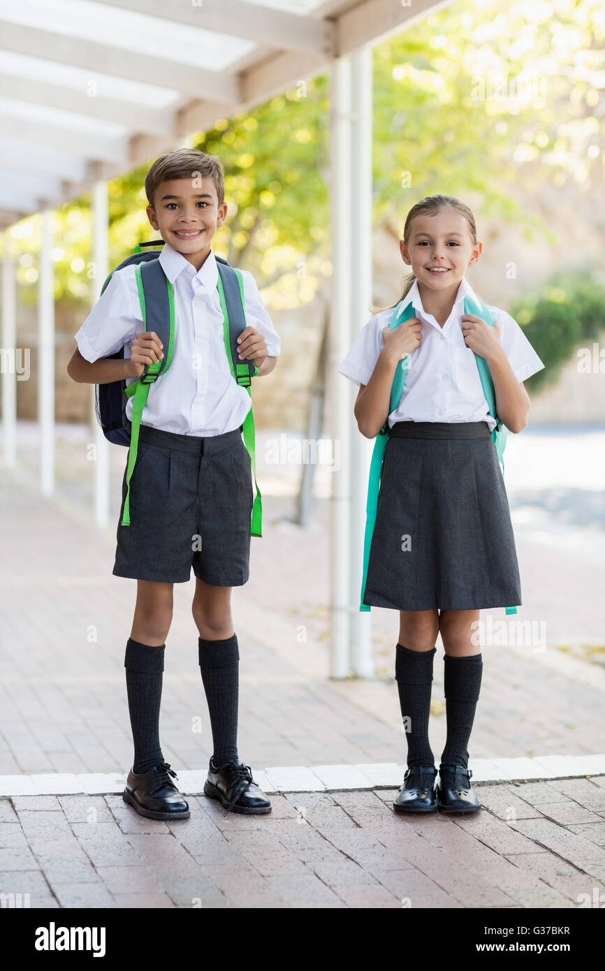 Smiling school kids standing in corridor Stock Photo - Alamy