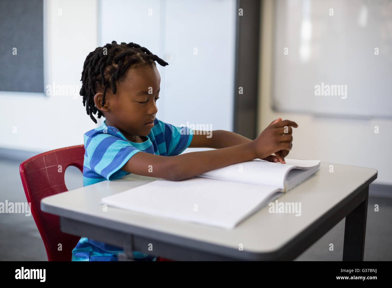 School boy memorizing the lesson in classroom Stock Photo