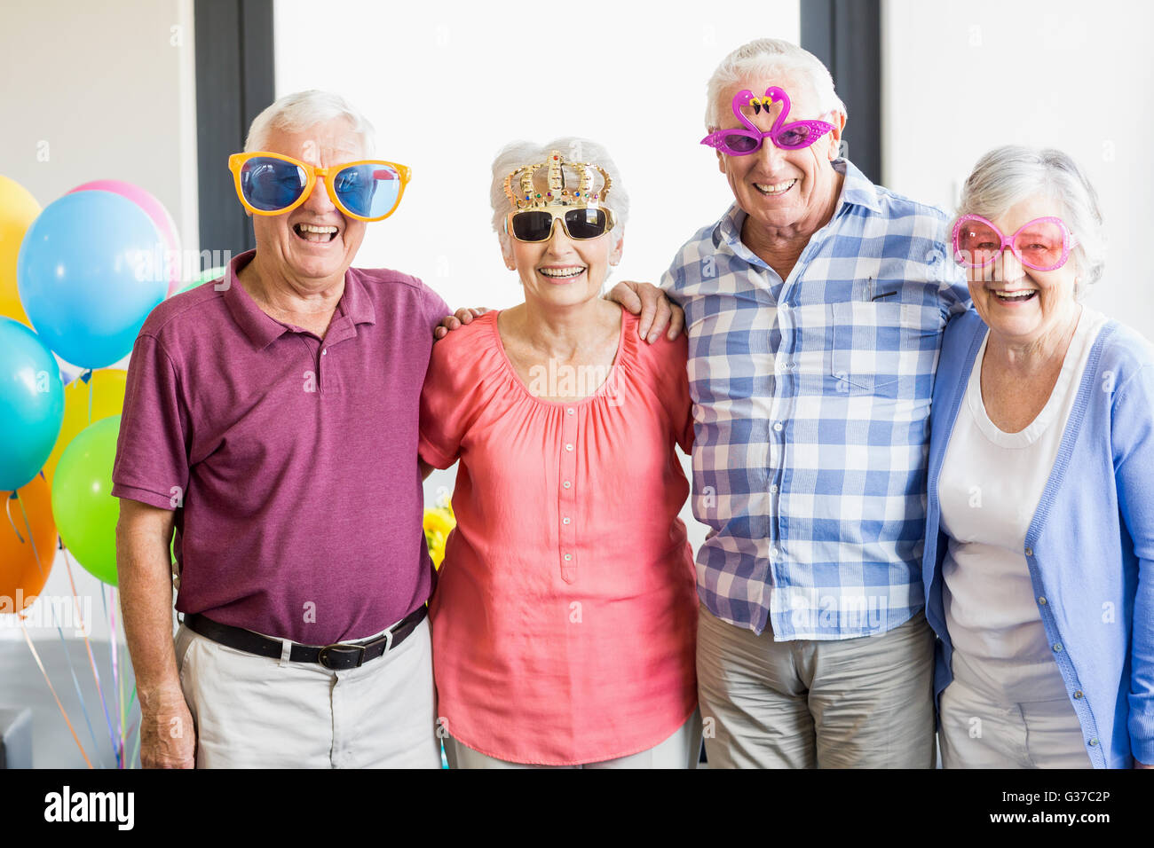 Seniors wearing funny glasses Stock Photo