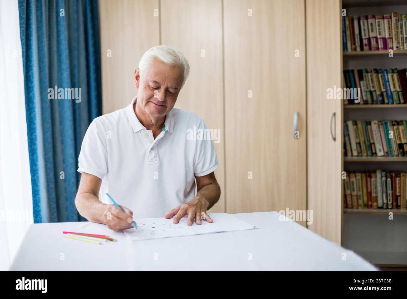 Senior man using a colouring book Stock Photo
