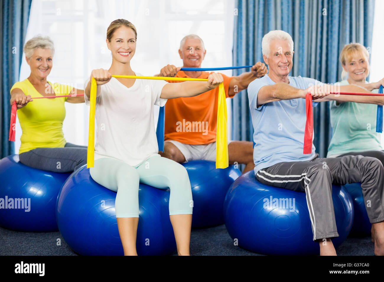 Seniors using exercise ball stretching hires stock photography and