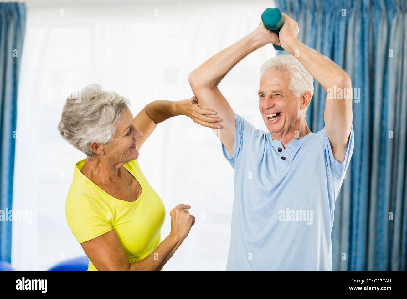 Senior woman feeling muscles of man Stock Photo