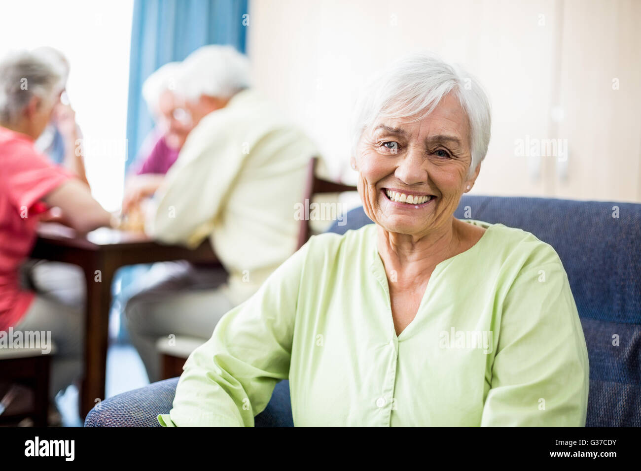 Senior woman sitting on a couch Stock Photo Alamy