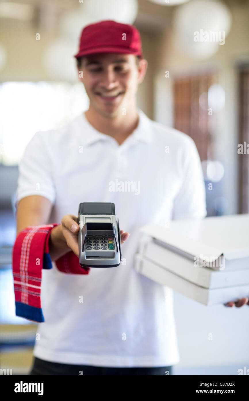 Happy pizza delivery man showing credit card machine Stock Photo Alamy