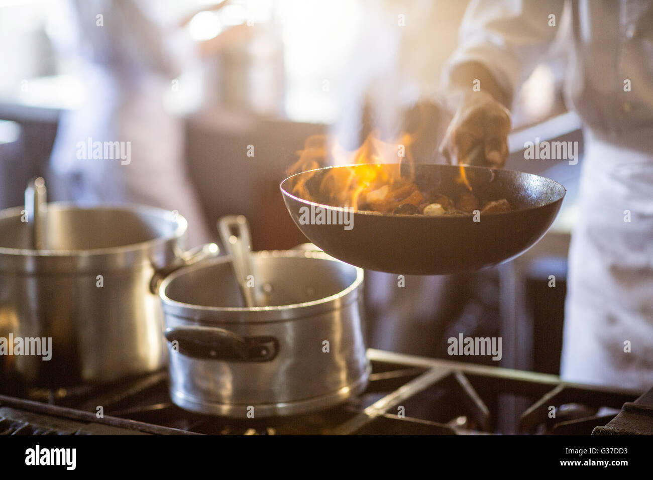 Chef cooking in kitchen stove Stock Photo