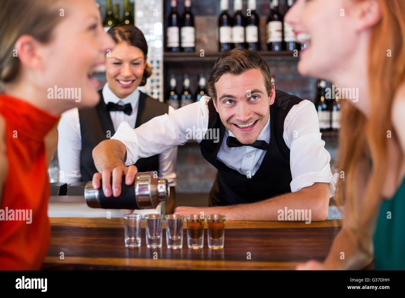 Bartender pouring tequila into shot glasses Stock Photo Alamy