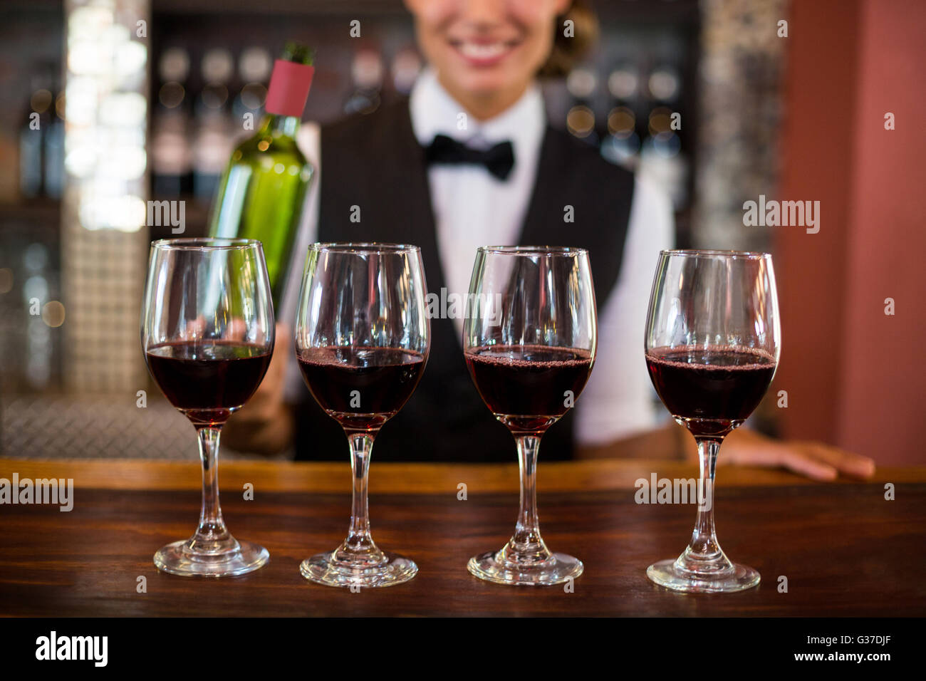Four glasses of red wine ready to serve on bar counter Stock Photo Alamy