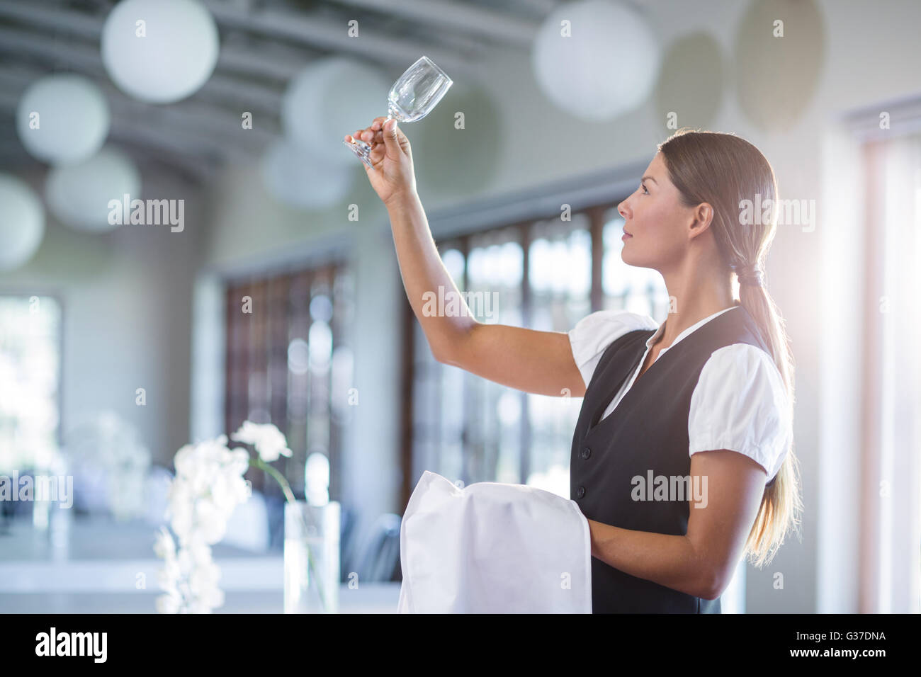 Smiling waitress holding up a empty wine glass Stock Photo