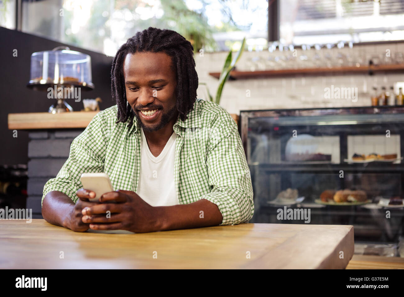 Young man using mobile phone in cafeteria Stock Photo