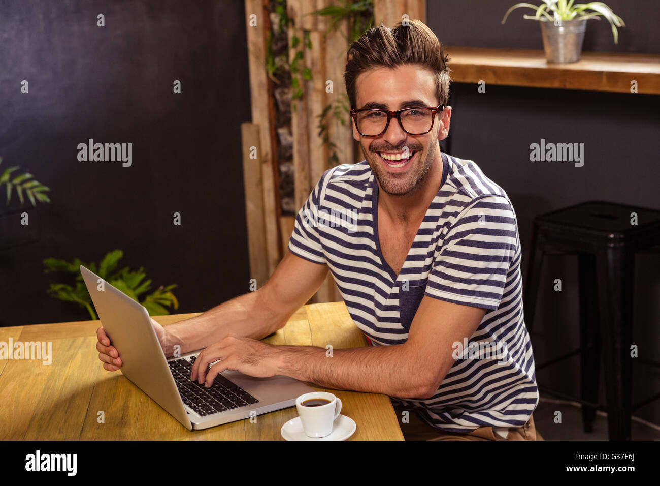 Young man using laptop in cafeteria Stock Photo