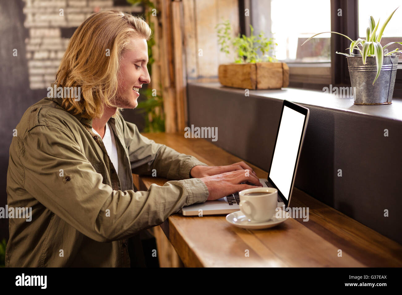 Young man using laptop in cafeteria Stock Photo