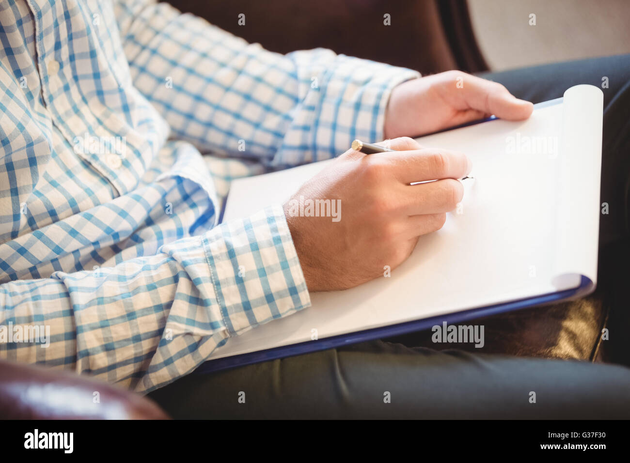 Business man writing on his clipboard Stock Photo - Alamy